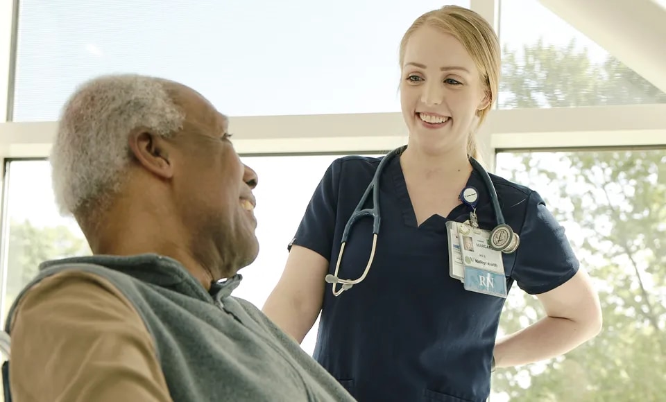 Female nurse talking to patient in wheelchair