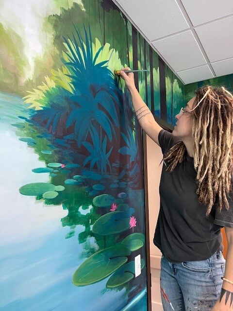 woman paints mural