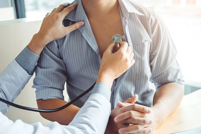 patient getting heart listened to with stethoscope