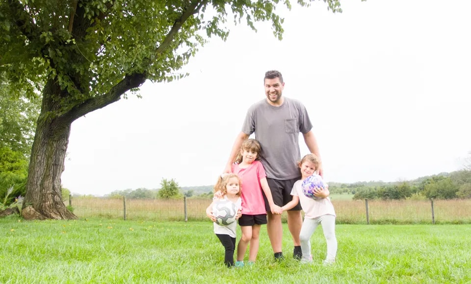A dad with his three young kids outdoors