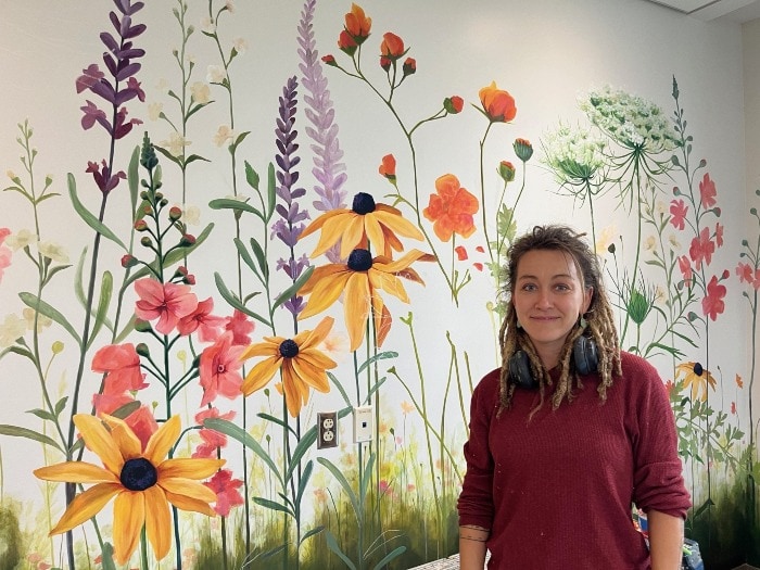 artist standing in front of mural