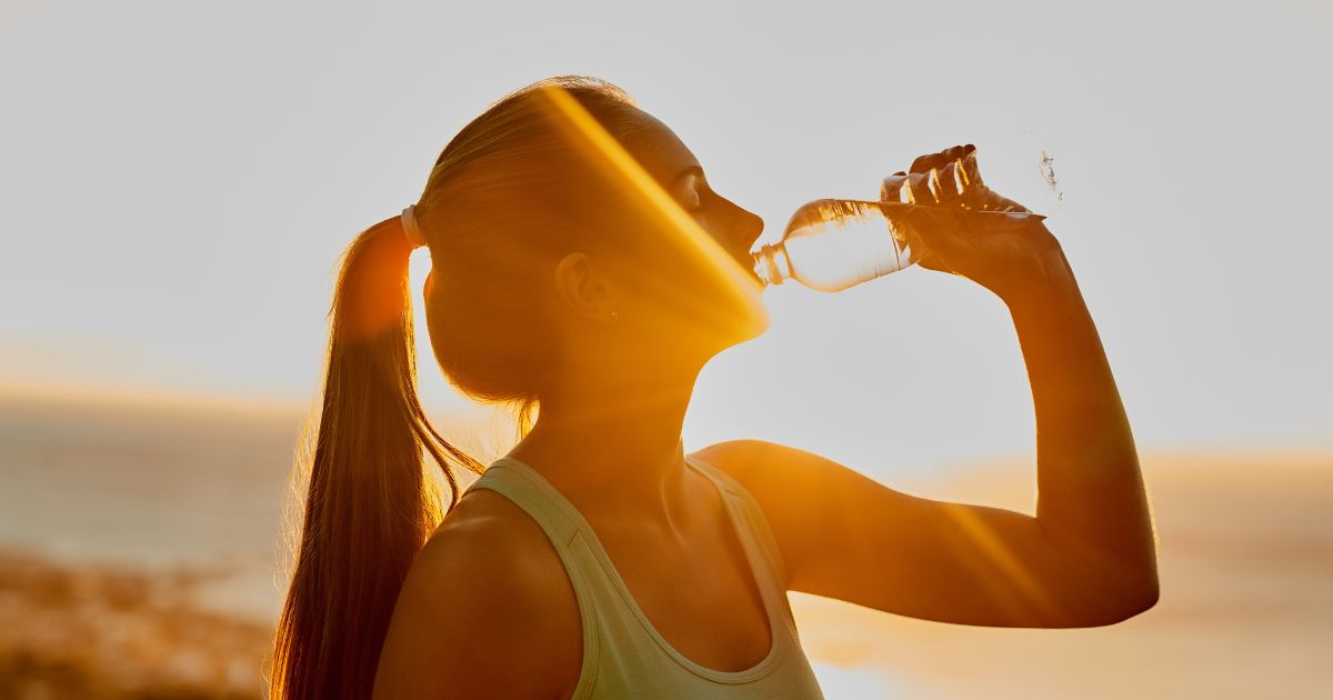 woman drinking water in sunlight