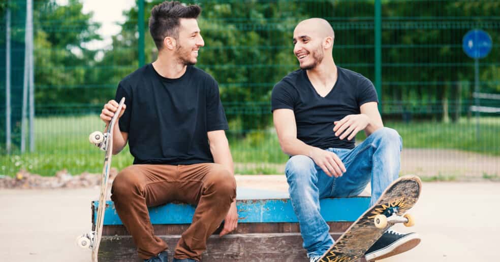 two men on bench with skateboard