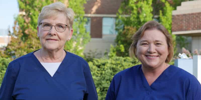Two female hospital staff smiling