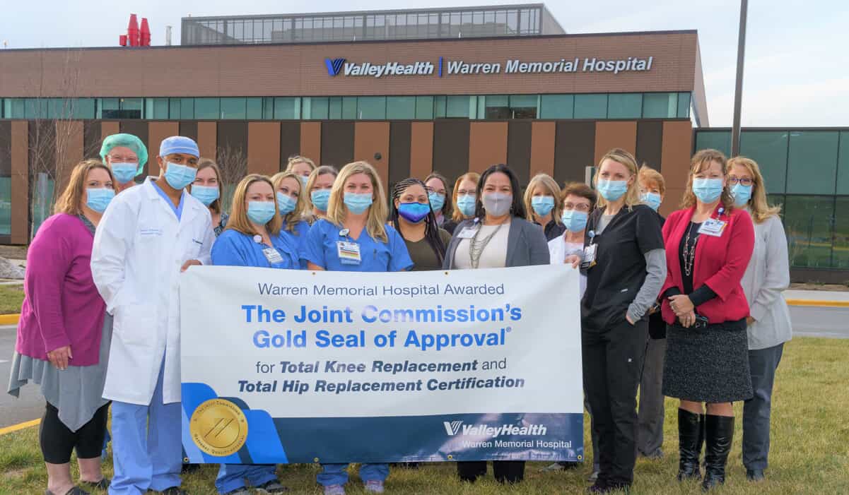 Warren Memorial Hospital Staff holding a Gold seal tarpauline