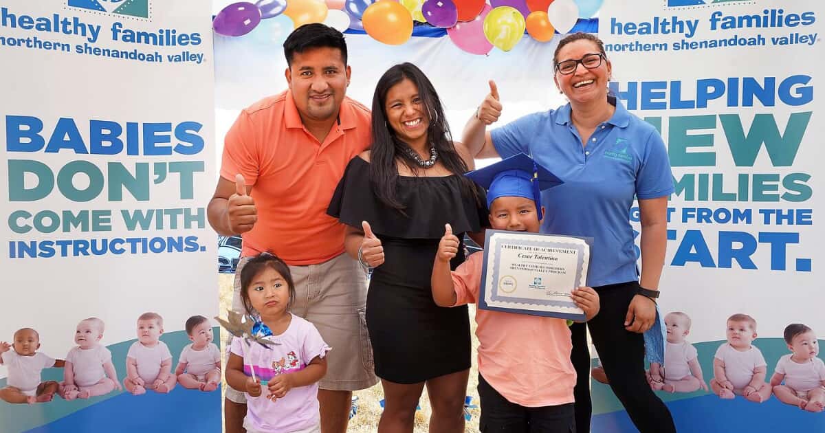 family posing for a photo with a staff