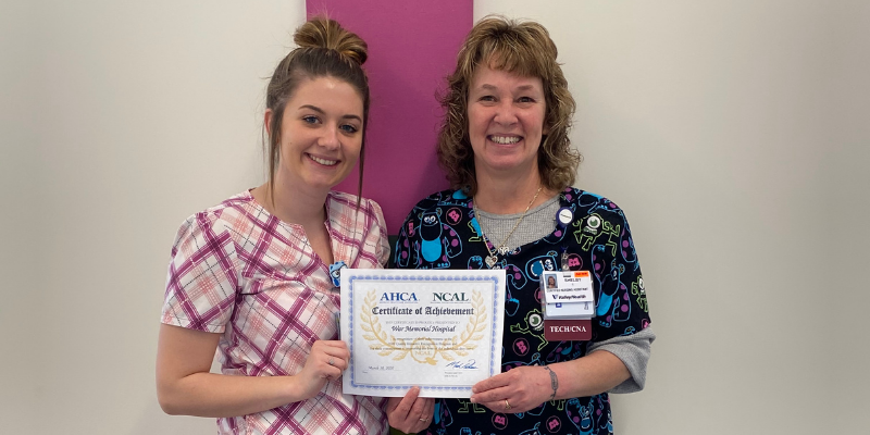 Two ladies showing a certificate